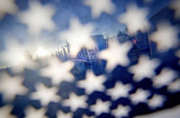 <p>The grave of U.S. Marine Lance Cpl. Michael Harris is seen through an American flag as the the sun rises over Georgia National Cemetery in Canton, Ga., May 28, 2012. Harris died Feb 6, 2012 at the age of 22 while serving in Afghanistan. (AP Photo/David Goldman) </p>