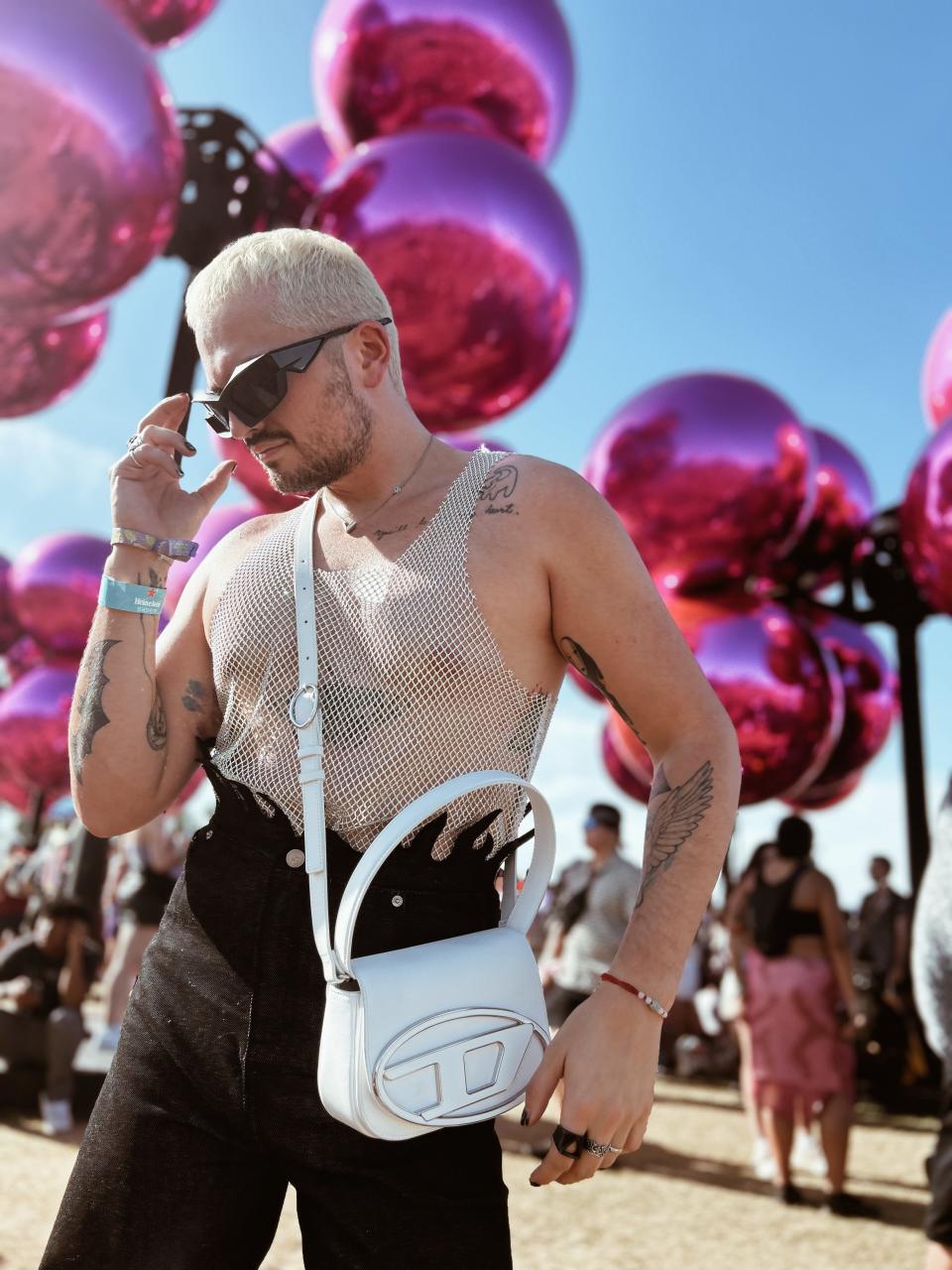 Christian Grotewold at coachella in sparkly top and white purse