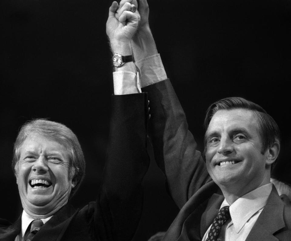 jimmy carter and walter mondale smiling and holding their hands in the air together