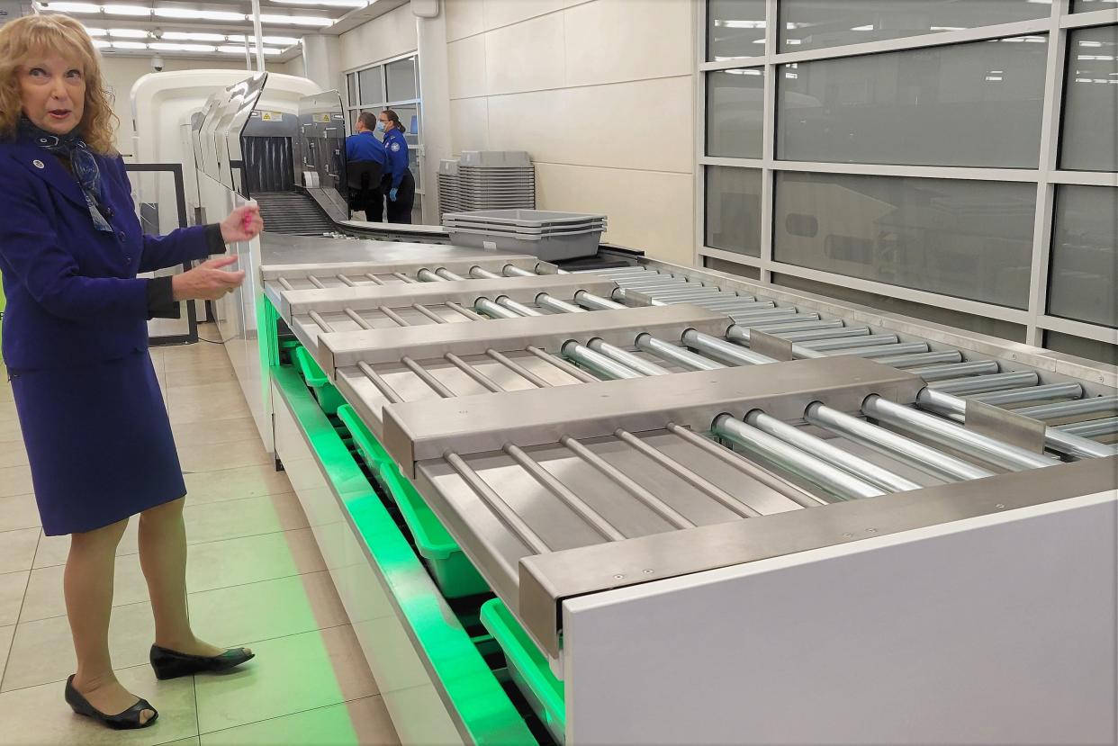 TSA spokeswoman Sari Koshetz shows the new  Checkpoint Property Screening System at Jacksonville International Airport that automatically moves bins for carry-on luggage for passengers (green-lit). It also uses new 3-D technology to look inside bags for forbidden items.