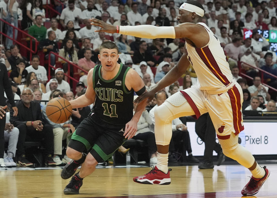 Boston Celtics guard Payton Pritchard (11) dribbles around Miami Heat center Bam Adebayo, right, during the first half of Game 4 of an NBA basketball first-round playoff series Monday, April 29, 2024, in Miami. (AP Photo/Marta Lavandier)