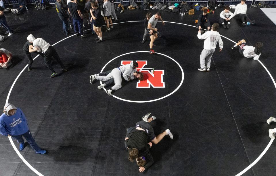 Wrestlers warm up on mats set up on the stage on Day One at NSIAA Wrestling Championships in Atlantic City on March 2, 2023. 