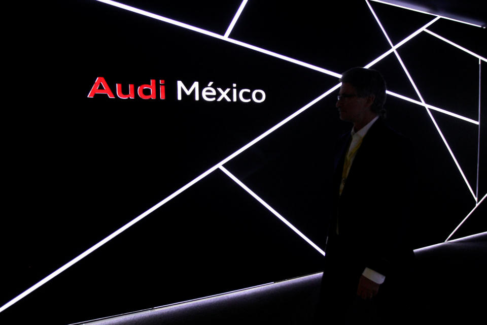 Man walks past the logo of Audi during the opening of a new plant in San Jose Chiapa