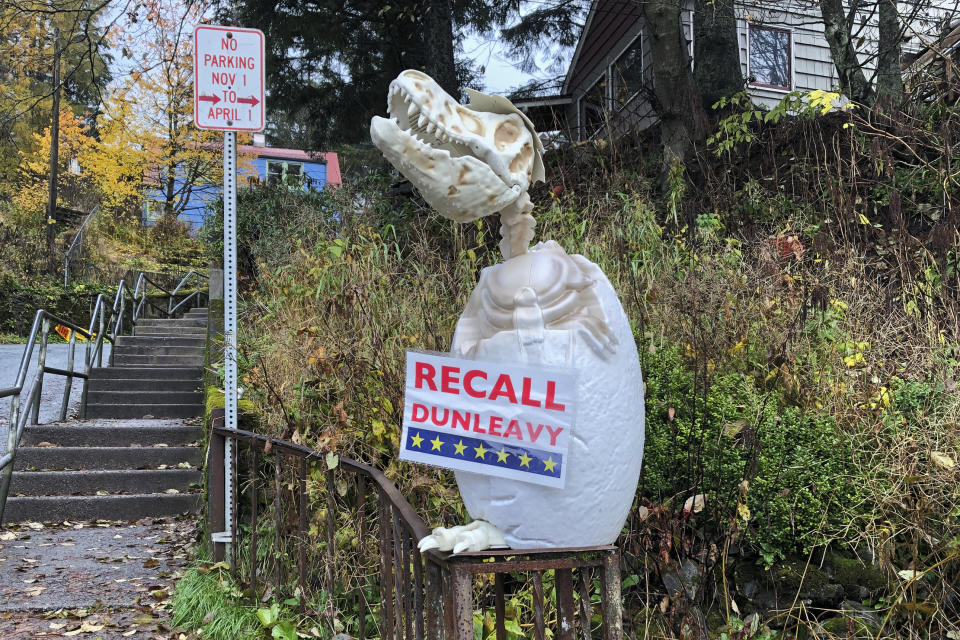 In this Friday, Nov. 1, 2019, photo, a sign reading "Recall Dunleavy" hangs from a decoration in front of a yard near the Alaska governor's mansion in Juneau, Alaska. A fight is brewing in the state over whether Republican Gov. Mike Dunleavy should be recalled from office, with his critics saying he's incompetent and has recklessly tried to cut spending while supporters see a politically motivated attempt to undo the last election. (AP Photo/Becky Bohrer)