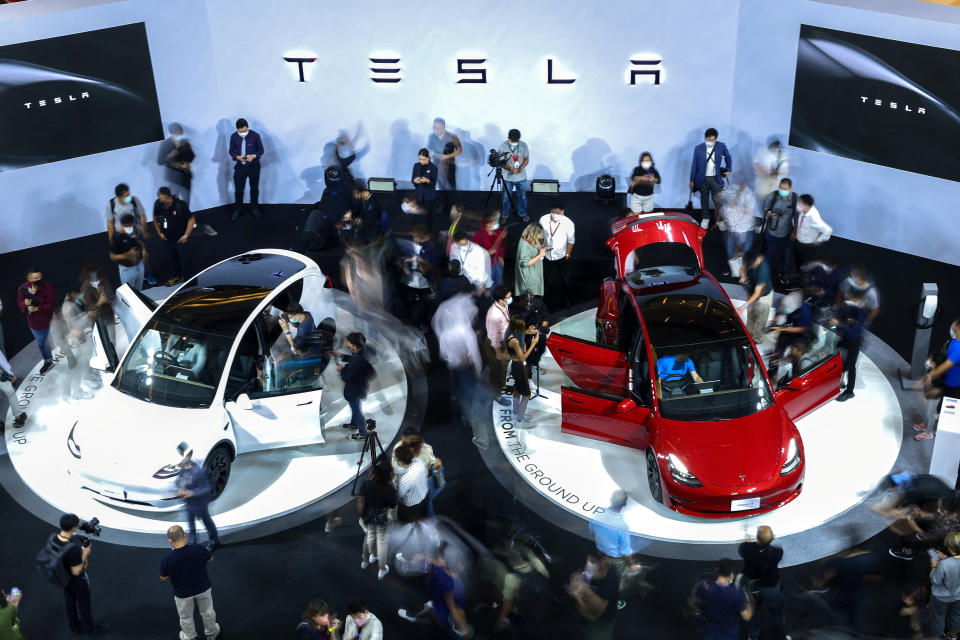 Members of media and guests surround the Tesla Model Y and Model 3 during Thailand Tesla's official launch event in Bangkok, Thailand, December 7, 2022. REUTERS/Athit Perawongmetha