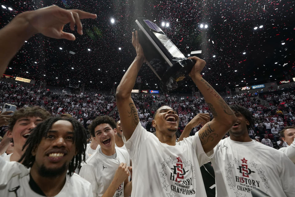 San Diego State forward Keshad Johnson holds up the trophy after San Diego State defeated Wyoming in an NCAA college basketball game to win the Mountain West Conference Saturday, March 4, 2023, in San Diego. (AP Photo/Gregory Bull)