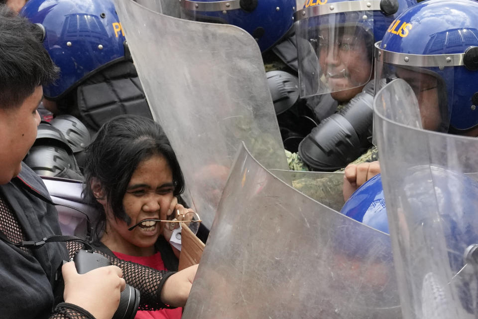 Police pushes a woman activist as they tried to march near the Malacanang presidential palace during an International Women's Day protest in Manila, Philippines on Friday, March 8, 2024. (AP Photo/Aaron Favila)
