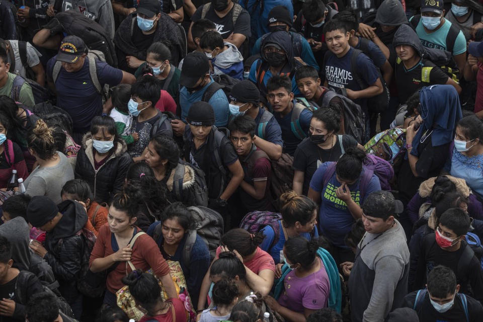 Migrants crowd into the patio at the Attorney Generals office after they were intercepted from inside cargo trailer trucks driving on the highway, in Coatzacoalcos, Veracruz state, Mexico, Friday, Nov. 19, 2021. About 500 migrants were riding in two cargo trucks when they were stopped and detained by the Criminal Investigation Agency and the National Immigration Institute, according to those two organizations. (AP Photo/Felix Marquez)