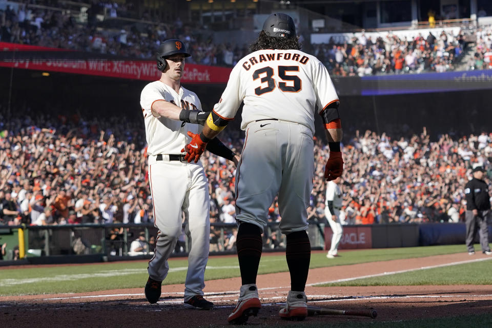 San Francisco Giants' Mike Yastrzemski, left, celebrates with Brandon Crawford after both scored on a two-run triple hit by Steven Duggar during the second inning of a baseball game against the Los Angeles Dodgers in San Francisco, Sunday, Sept. 5, 2021. (AP Photo/Jeff Chiu)