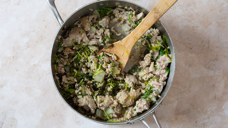 Ground turkey mixture in pan with wooden spoon
