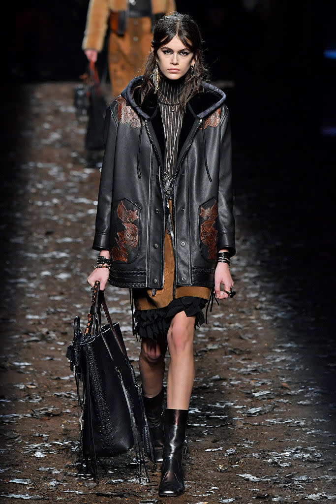 <p>Gerber wears a leather coat over a striped knit sweater and suede skirt at the Coach Fall 2018 show. (Photo: Getty) </p>