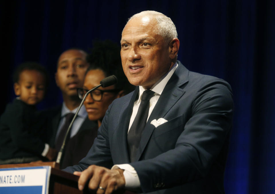 FILE - In this Nov. 27, 2018 file photo, Mississippi Democrat Mike Espy stands with family members as he talks to supporters in a crowded auditorium at the Mississippi Civil Rights Museum in Jackson, Miss., after losing the runoff election. On Tuesday, Nov. 12, 2019, Espy announced another run for U.S. Senate, setting up a 2020 rematch with Republican Cindy Hyde-Smith. (AP Photo/Charles A. Smith, File)