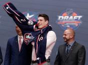 Jun 24, 2016; Buffalo, NY, USA; Pierre-Luc Dubois puts on a team jersey after being selected as the number three overall draft pick by the Columbus Blue Jackets in the first round of the 2016 NHL Draft at the First Niagra Center. Mandatory Credit: Timothy T. Ludwig-USA TODAY Sports