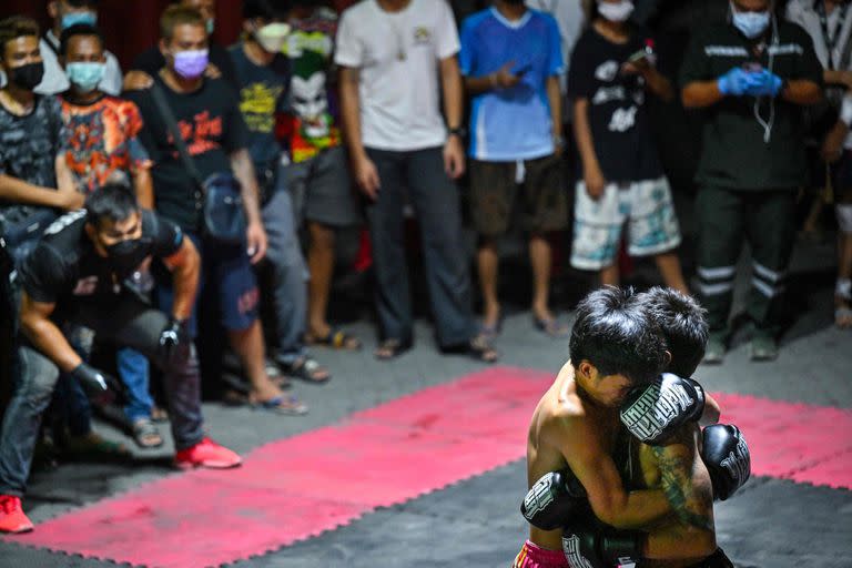 En trabada disputa los luchadores forcejean bajo la mirada y los gritos de los asistentes