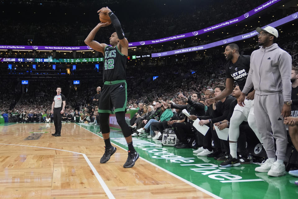 Boston Celtics center Al Horford (42) takes an uncontested 3-pointer, as Cleveland Cavaliers guard Donovan Mitchell, right, watches from the bench during the second half of Game 5 of an NBA basketball second-round playoff series Wednesday, May 15, 2024, in Boston. The Celtics advanced to the Eastern Conference finals. (AP Photo/Charles Krupa)