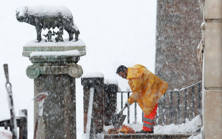 A worker removes the snow at the Campidoglio palace during an heavy snowfall in Rome, Italy February 26, 2018. REUTERS/Remo Casilli