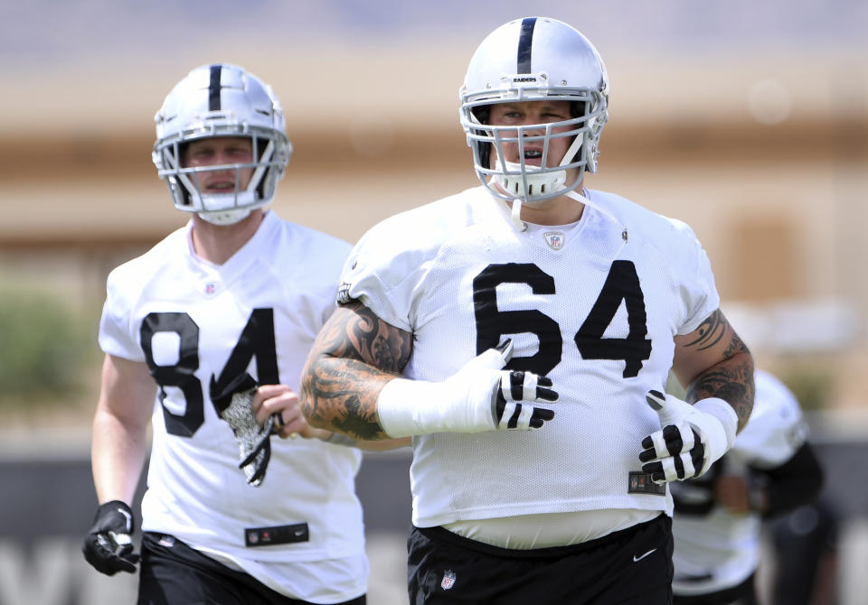 Las Vegas Raiders tight end Matt Bushman (84) and guard Richie Incognito (64) warm up during an NFL football organized team activity at the team's training facility Wednesday, May 26, 2021, in Henderson, Nev. (AP Photo/David Becker)