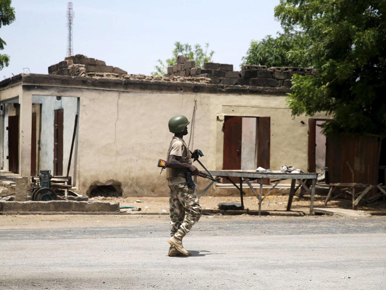 A soldier walks past a burnt building in Michika town in Adamawa state in 2015 after the Nigerian military recaptured it from Boko Haram: Reuters