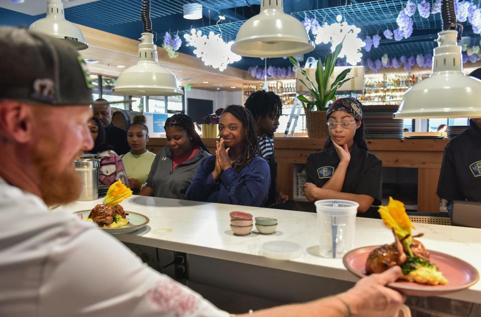 Server Saeeda Wansley (middle), 29, claps as Chef Tab Fuqua sets out the boudin-stuffed quail dish for the employees to try at Eudora's in The District at Eastover in Jackson on Tuesday, Oct. 24.