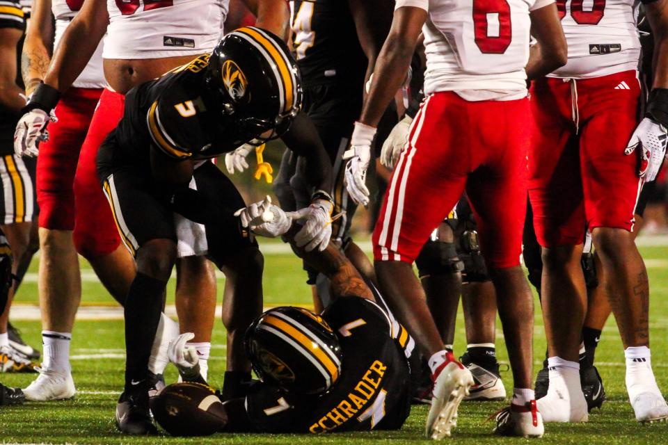 Missouri receiver Mookie Cooper (5) goes to help running back Cody Schrader (7) up after a play during a game against South Dakota at Memorial Stadium on August 31, 2023, in Columbia, Mo.