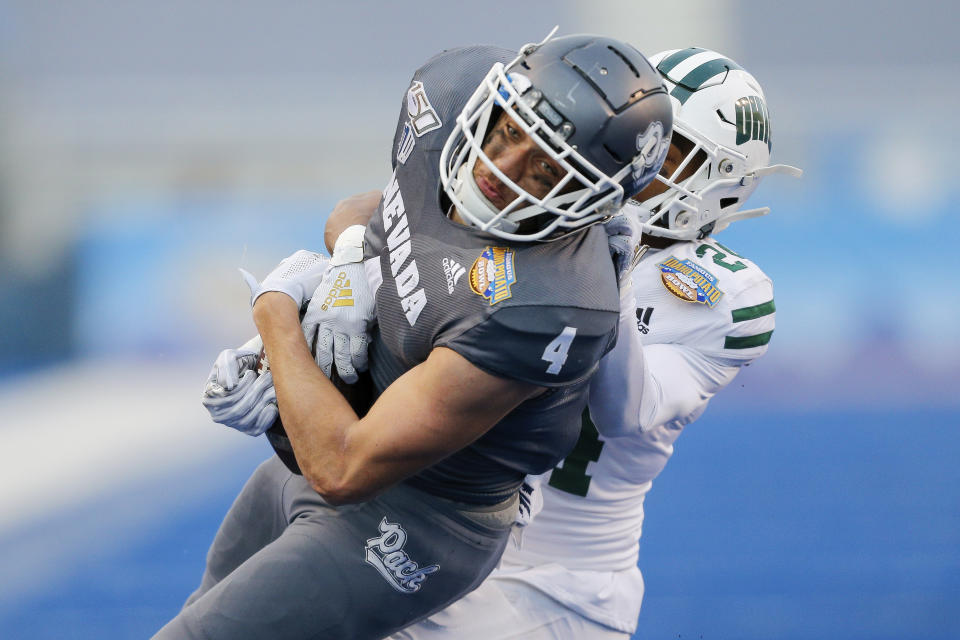 Nevada wide receiver Elijah Cooks (4) hangs onto the the ball for a 26-yard reception as Ohio cornerback Xavior Motley, behind, tries to dislodge it in the second half of the Famous Idaho Potato Bowl NCAA college football game Friday, Jan. 3, 2020, in Boise, Idaho. (AP Photo/Steve Conner)