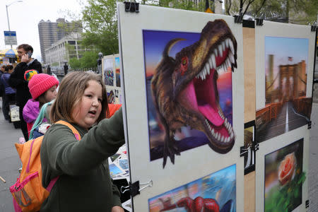 FILE PHOTO: Climate change activist Zayne Cowie looks at street art on the Brooklyn Bridge during a youth climate march in New York City, U.S., May 3, 2019. REUTERS/Brendan McDermid