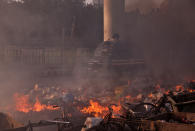 A police vehicle moves past burning debris that was set on fire by demonstrators in a riot affected area after fresh clashes erupted between people demonstrating for and against a new citizenship law in New Delhi, India, February 25, 2020. REUTERS/Danish Siddiqui