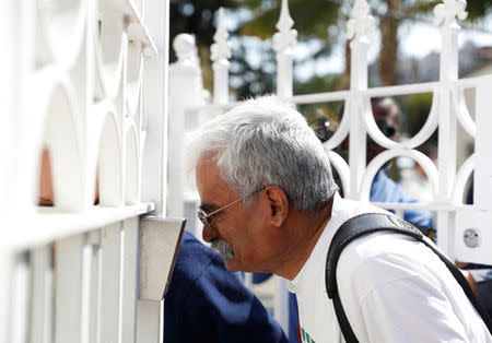 A man speaks into an intercom speaker outside the entrance to the building of the Consulate General of Russia in San Francisco, California, U.S., August 31, 2017. REUTERS/Stephen Lam