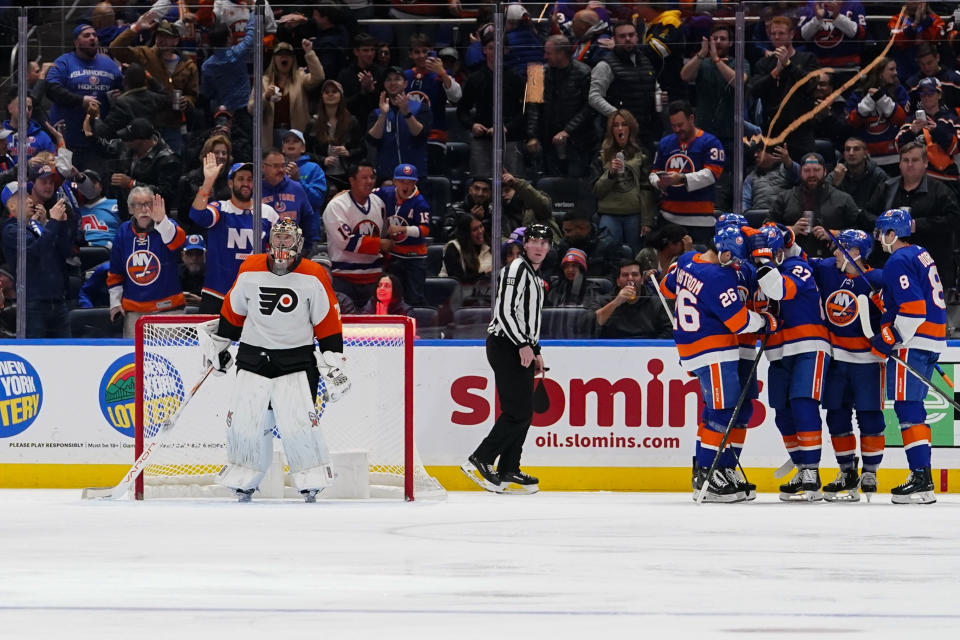 New York Islanders celebrate a goal by Anders Lee against Philadelphia Flyers goaltender Carter Hart during the first period of an NHL hockey game Wednesday, Nov. 22, 2023, in Elmont, N.Y. (AP Photo/Frank Franklin II)