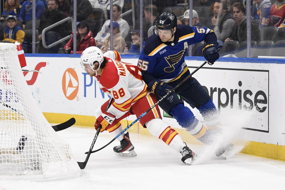 St. Louis Blues' Colton Parayko (55) pressures Calgary Flames' Andrew Mangiapane (88) during the first period of an NHL hockey game Thursday, Jan. 12, 2023, in St. Louis. (AP Photo/Jeff Le)