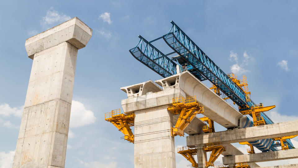 Construction of a mass transit train line in progress with heavy infrastructure.