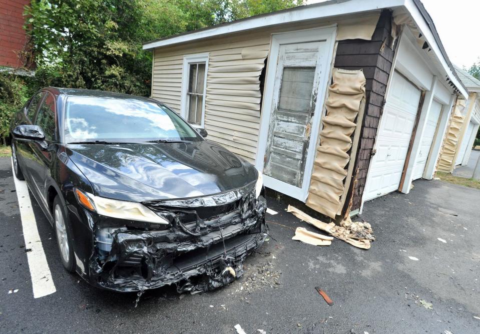 Intense flames melted the front of a car and the vinyl siding on two garages in back of a rooming house at 100 Bigelow St. in Quincy that was destroyed by an early morning, multi-alarm fire, Sunday, July 31, 2022.