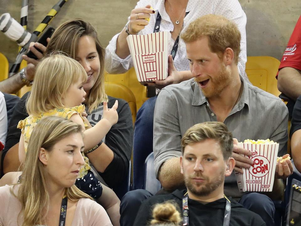 A young spectator tries to steal Prince Harry's popcorn