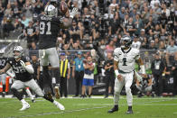 Las Vegas Raiders defensive end Yannick Ngakoue (91) blocks an attempted pass by Philadelphia Eagles quarterback Jalen Hurts (1) during the first half of an NFL football game, Sunday, Oct. 24, 2021, in Las Vegas. (AP Photo/David Becker)