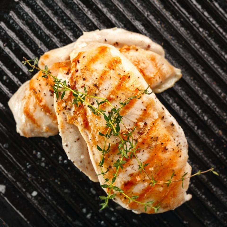 grilled chicken with spices on black background