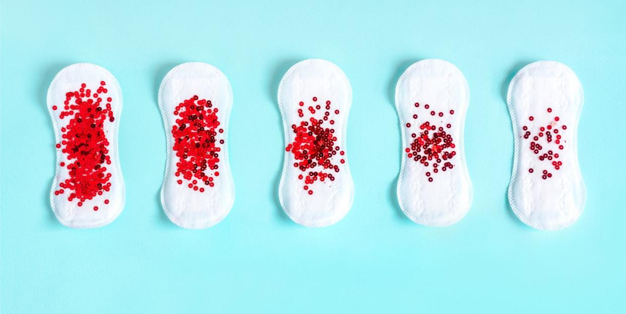 menstrual pads with red glitter on colored background