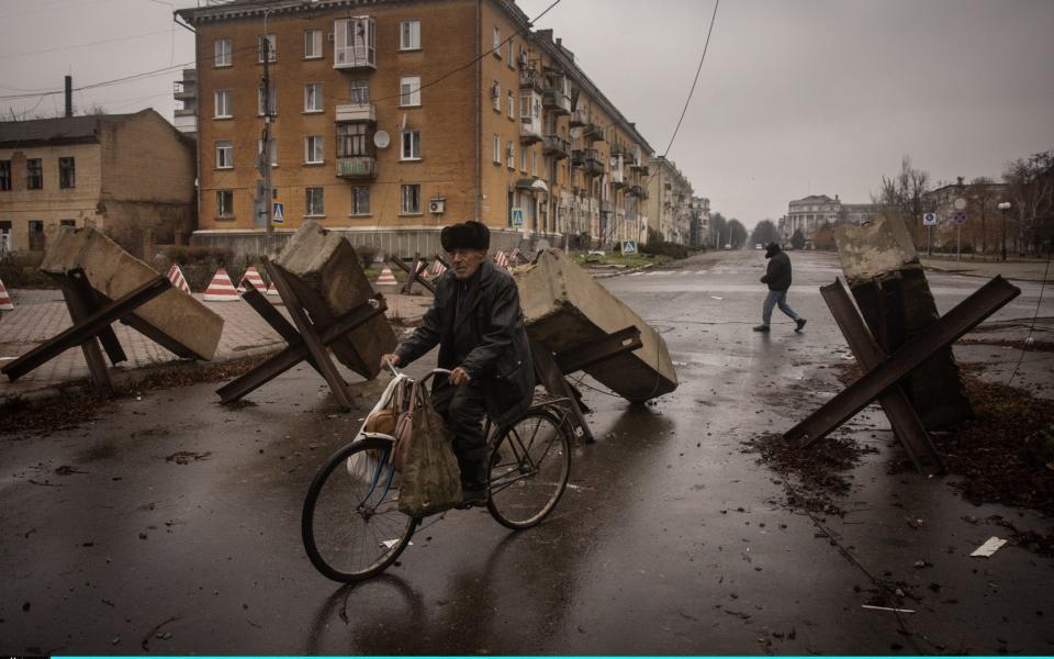 A resident rides his bike through street barricades in Bakhmut, Ukraine - Chris McGrath/Getty Images Europe