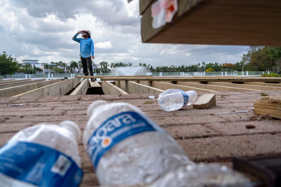 As the temperature reaches 95 degrees and the feels like of 110 degrees, Chris Blankenship of Marine Construction downs a bottle of water while building a deck in Palm Beach Gardens, Florida on July 6, 2023.