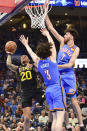 Utah Jazz forward John Collins (20) shoots over Oklahoma City Thunder guard Josh Giddey (3) and forward Chet Holmgren (7) in the second half of an NBA basketball game, Wednesday, March 20, 2024, in Oklahoma City. (AP Photo/Kyle Phillips)