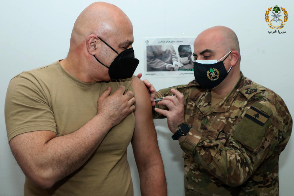 In this photo released by the Lebanese Army official website, Lebanese Army Commander Gen. Joseph Aoun, receives a Sinopharm COVID-19 vaccine, at one of the military vaccination centers, in Beirut, Lebanon, Thursday, April 8, 2021. The Lebanese army said Aoun was the first to get the vaccine and that thousands of soldiers will be vaccinated in the coming weeks. Lebanon received a gift of 90,000 Sinopharm shots from China last week. (Lebanese Army Website via AP)