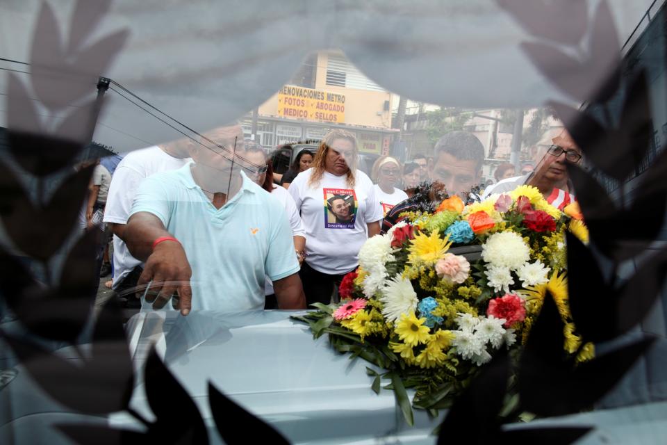 <p>Friends of Juan Carlos Nieves Rodriguez, one of the victims of the shooting at the Pulse night club in Orlando, Fla., are seen through a window of the hearse that will transport Nieves’ body to the cemetery, outside the funeral parlor at his hometown of Caguas, Puerto Rico, June 20, 2016. (Reuters/Alvin Baez) </p>