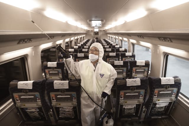 An employee sprays disinfectant on a train as a precaution against coronavirus at Suseo Station in Seoul, South Korea