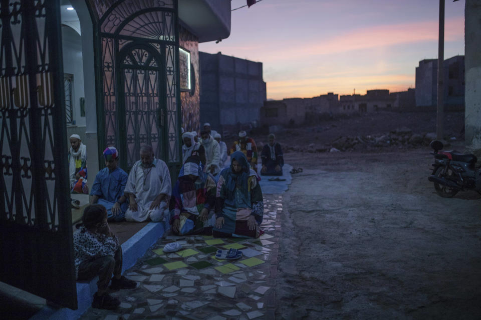 Members of the Sufi Karkariya order pray the sunset Maghreb prayer during a religious celebration of the birthday of the prophet Muhammed, in Aroui, near Nador, eastern Morocco, Monday, Oct. 18, 2021. It was the first such gathering since the pandemic. The order, the Karkariya, follows a mystical form of Islam recognizable by its unique dress code: A modest yet colorful patchwork robe.(AP Photo/Mosa'ab Elshamy)