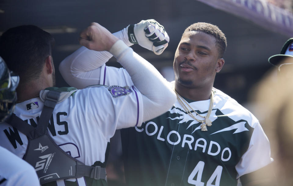 Colorado Rockies' Austin Wynns, left, congratulates Elehuris Montero as he returns to the dugout after hitting a two-run home run off Chicago Cubs starting pitcher Jameson Taillon in the fifth inning of a baseball game, Wednesday, Sept. 13, 2023, in Denver. (AP Photo/David Zalubowski)