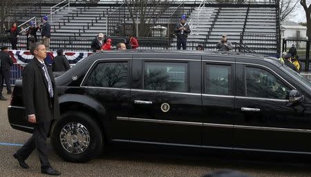 Secret Service agents walk alongside of U.S. President Donald Trump's limousine as it passes empty viewing bleachers as he participates in the inaugural parade after his swearing in at the Capitol in Washington, U.S., January 20, 2017. REUTERS/Carlos Barria