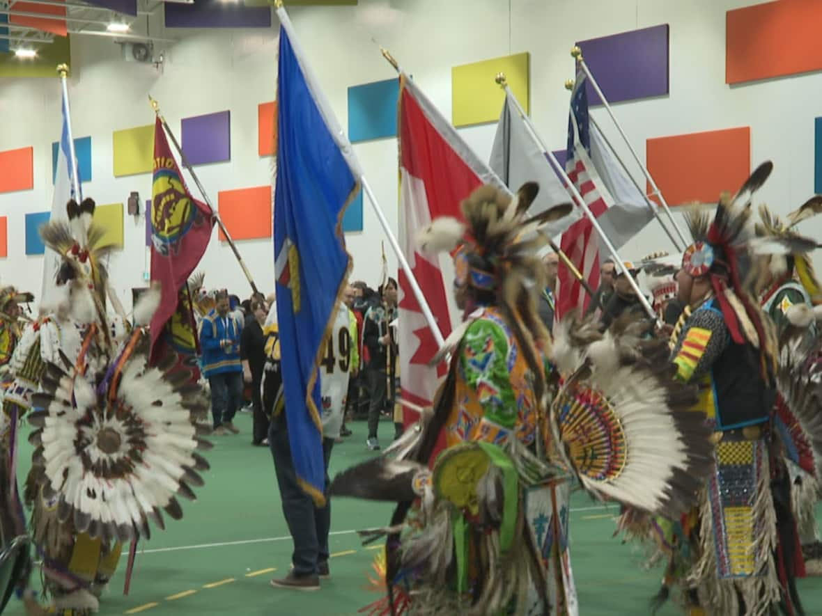 The grand entry of the Lead By Example Powwow at the Strathmore Motor Products Sports Centre.  (Terri Trembath/CBC - image credit)