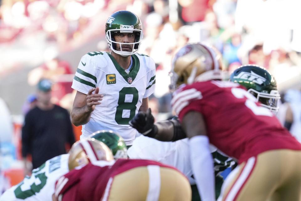 Jets quarterback Aaron Rodgers (8) signals at the line of scrimmage during a game against the 49ers.