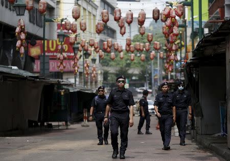 Police patrol a Chinese area of town where shops have closed for the day as "Red Shirt" demonstrators gather for a rally to celebrate Malaysia Day and to counter a massive protest held over two days last month that called for Prime Minister Najib Razak's resignation over a graft scandal, in Malaysia's capital city of Kuala Lumpur September 16, 2015. REUTERS/Olivia Harris