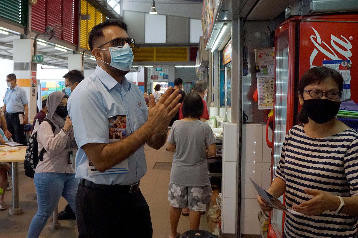 Workers’ Party chief Pritam Singh speaking with a hawker during a party walkabout in Bedok North on 27 June 2020. (PHOTO: Dhany Osman / Yahoo News Singapore)