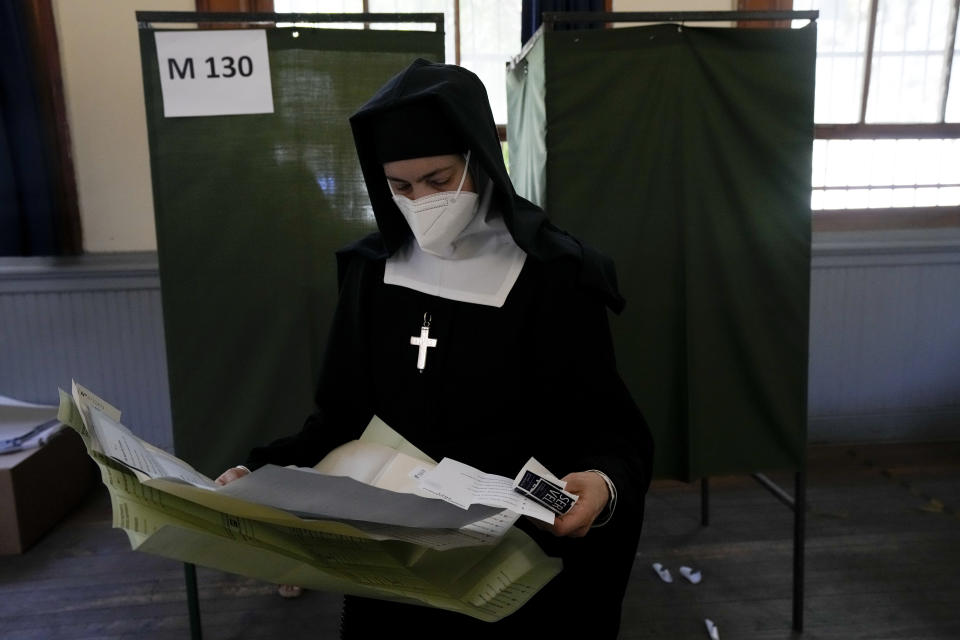 A nun holds the ballot papers at a polling station during presidential elections in Santiago, Chile, Sunday, Nov. 21, 2021. (AP Photo/Esteban Felix)